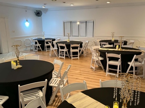 Reception hall dining area with candlelit crystal centerpieces and black linens