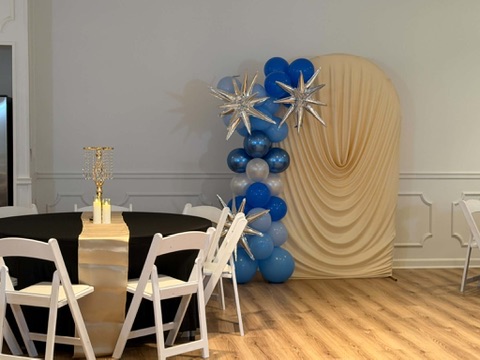 Champagne draped archway with blue balloon garland and silver star accents