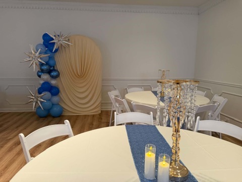 Close-up of crystal candelabra centerpiece, warm LED candles, and blue glitter table runner